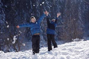 niños jugando con nieve fresca foto