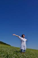 young woman with spreading arms to sky photo