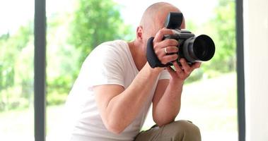 Photographer takes pictures with DSLR camera photo