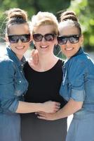 portrait of three young beautiful woman with sunglasses photo