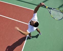 joven jugar al tenis al aire libre foto