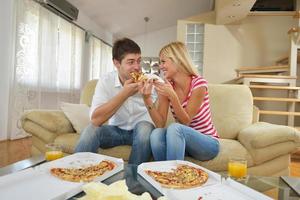 pareja en casa comiendo pizza foto