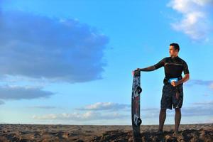 Portrait of a young  kitsurf  man at beach on sunset photo
