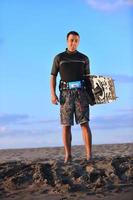 Portrait of a young  kitsurf  man at beach on sunset photo