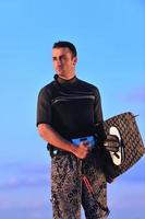 Portrait of a young  kitsurf  man at beach on sunset photo