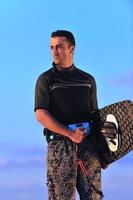 Portrait of a young  kitsurf  man at beach on sunset photo