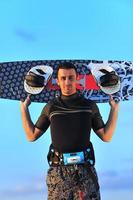 Portrait of a young  kitsurf  man at beach on sunset photo