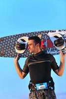 Portrait of a young  kitsurf  man at beach on sunset photo