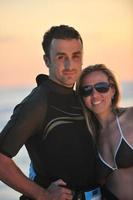 surf couple posing at beach on sunset photo