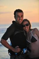 surf couple posing at beach on sunset photo