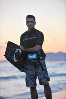 Portrait of a young  kitsurf  man at beach on sunset photo