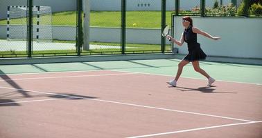 mujer joven jugar juego de tenis al aire libre foto