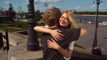 Young girl and boy have a hug on a sunny afternoon in a city park video