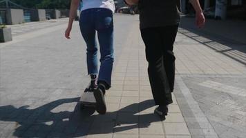 Boy and Girl teenagers have fun at the park with a skateboard video