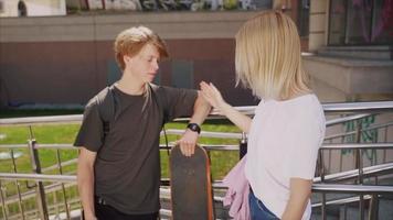 jongen en meisje tieners hebben pret Bij de park met een skateboard video