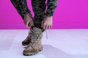 soldier tying the laces on his boots photo