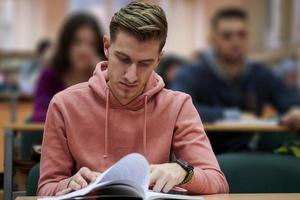 estudiante tomando notas mientras estudia en la escuela secundaria foto