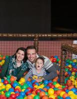 padres e hijos jugando en la piscina con bolas de colores foto