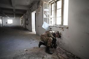 soldado en acción cerca de la revista de cambio de ventana y ponerse a cubierto foto