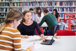 el estudiante usa un cuaderno y una biblioteca escolar foto