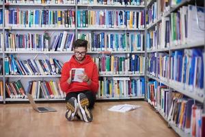 los estudiantes usan un cuaderno, una computadora portátil y una biblioteca escolar foto