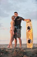 surf couple posing at beach on sunset photo