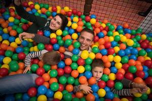 padres jóvenes con hijos en una sala de juegos para niños foto