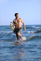 Portrait of a young  kitsurf  man at beach on sunset photo