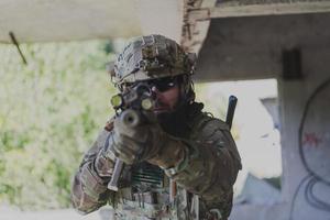 A bearded soldier in uniform of special forces in a dangerous military action in a dangerous enemy area. Selective focus photo