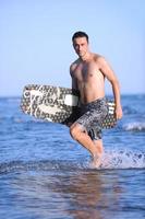 Portrait of a young  kitsurf  man at beach on sunset photo