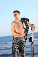 Portrait of a young  kitsurf  man at beach on sunset photo