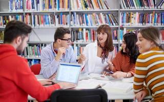 grupo de estudiantes trabajando juntos en un proyecto escolar en una tableta en una universidad moderna foto