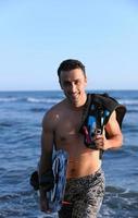 Portrait of a young  kitsurf  man at beach on sunset photo