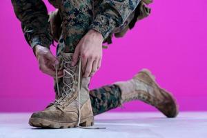 soldado atando los cordones de sus botas foto