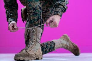 soldado atando los cordones de sus botas foto