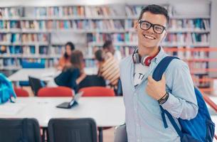 el estudiante usa un cuaderno, una computadora portátil y una biblioteca escolar foto