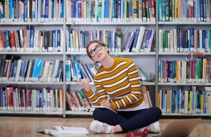 the student uses a notebook and a school library photo