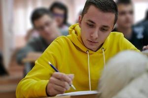 estudiante tomando notas mientras estudia en la escuela secundaria foto