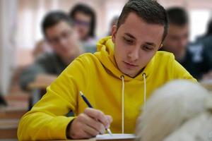 estudiante tomando notas mientras estudia en la escuela secundaria foto