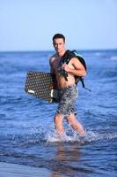 Portrait of a young  kitsurf  man at beach on sunset photo