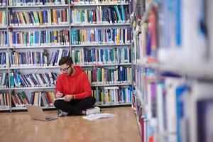 los estudiantes usan un cuaderno, una computadora portátil y una biblioteca escolar foto