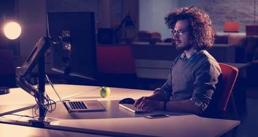 man working on computer in dark office photo