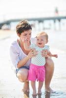 mamá y bebé en la playa se divierten foto