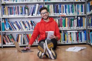 los estudiantes usan un cuaderno, una computadora portátil y una biblioteca escolar foto