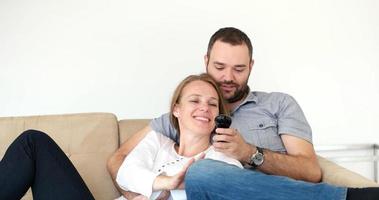 pareja mayor viendo la televisión en una villa moderna foto