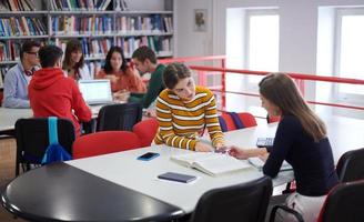 grupo de estudiantes trabajando juntos en un proyecto escolar en una tableta en una universidad moderna foto