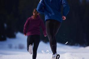 couple jogging outside on snow photo