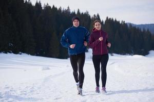 pareja trotando afuera en la nieve foto