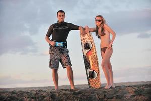 surf couple posing at beach on sunset photo