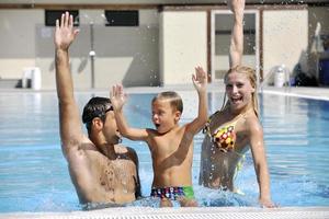 happy young family have fun on swimming pool photo